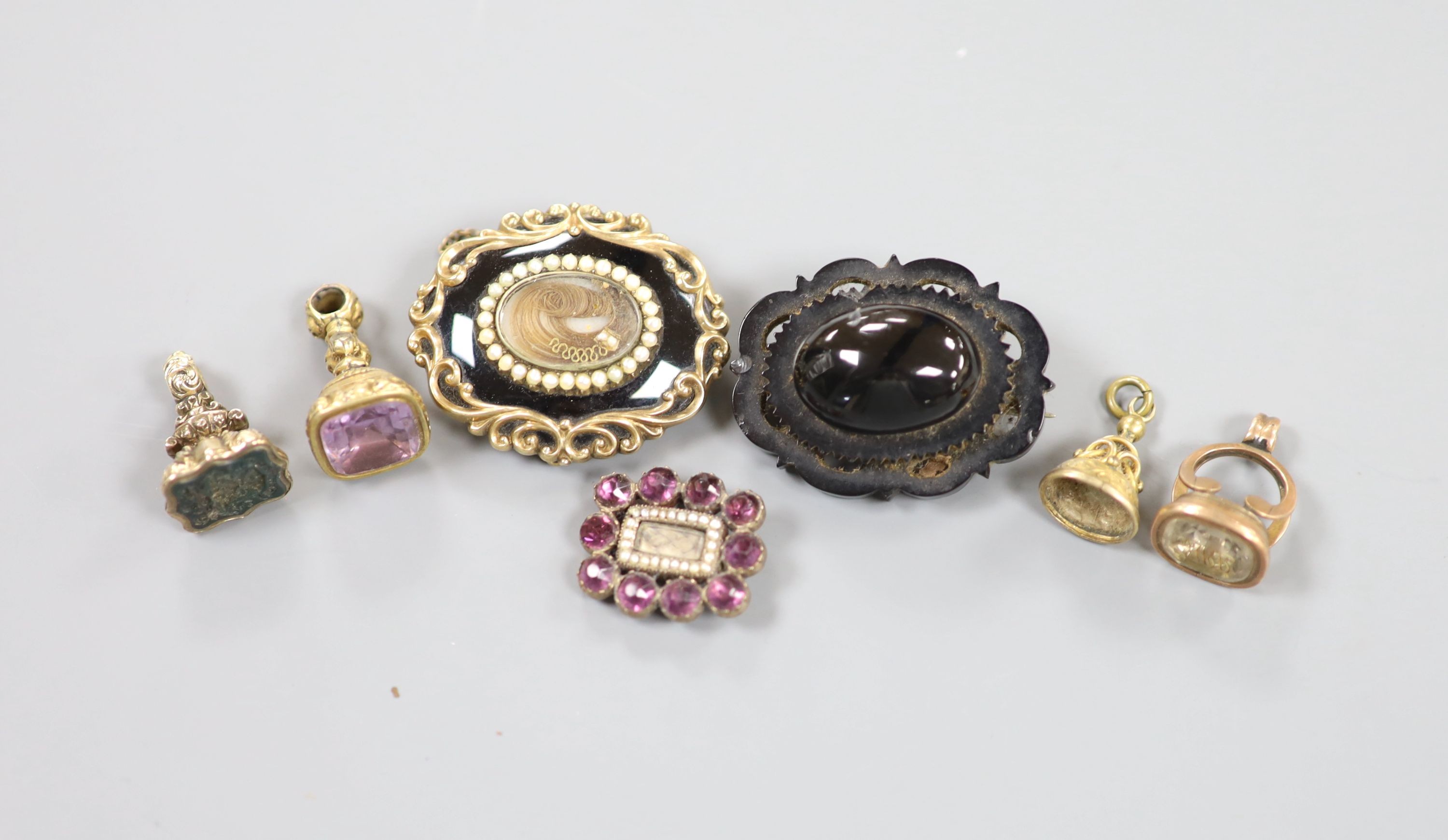 A Victorian yellow metal overlaid and bloodstone set fob seal, 24mm, three other fob seals, one with vacant matrix and three mourning brooches, including seed pearl and black enamel, 40mm.